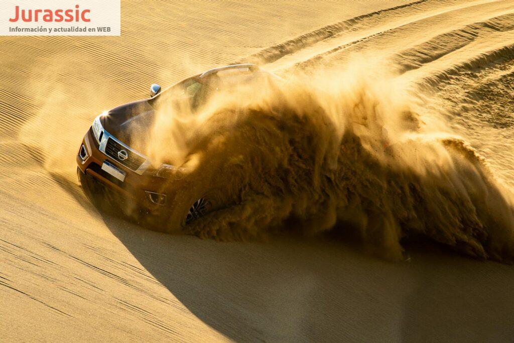 Dynamic shot of an SUV kicking up sand as it speeds through dunes in Cariló, Argentina.